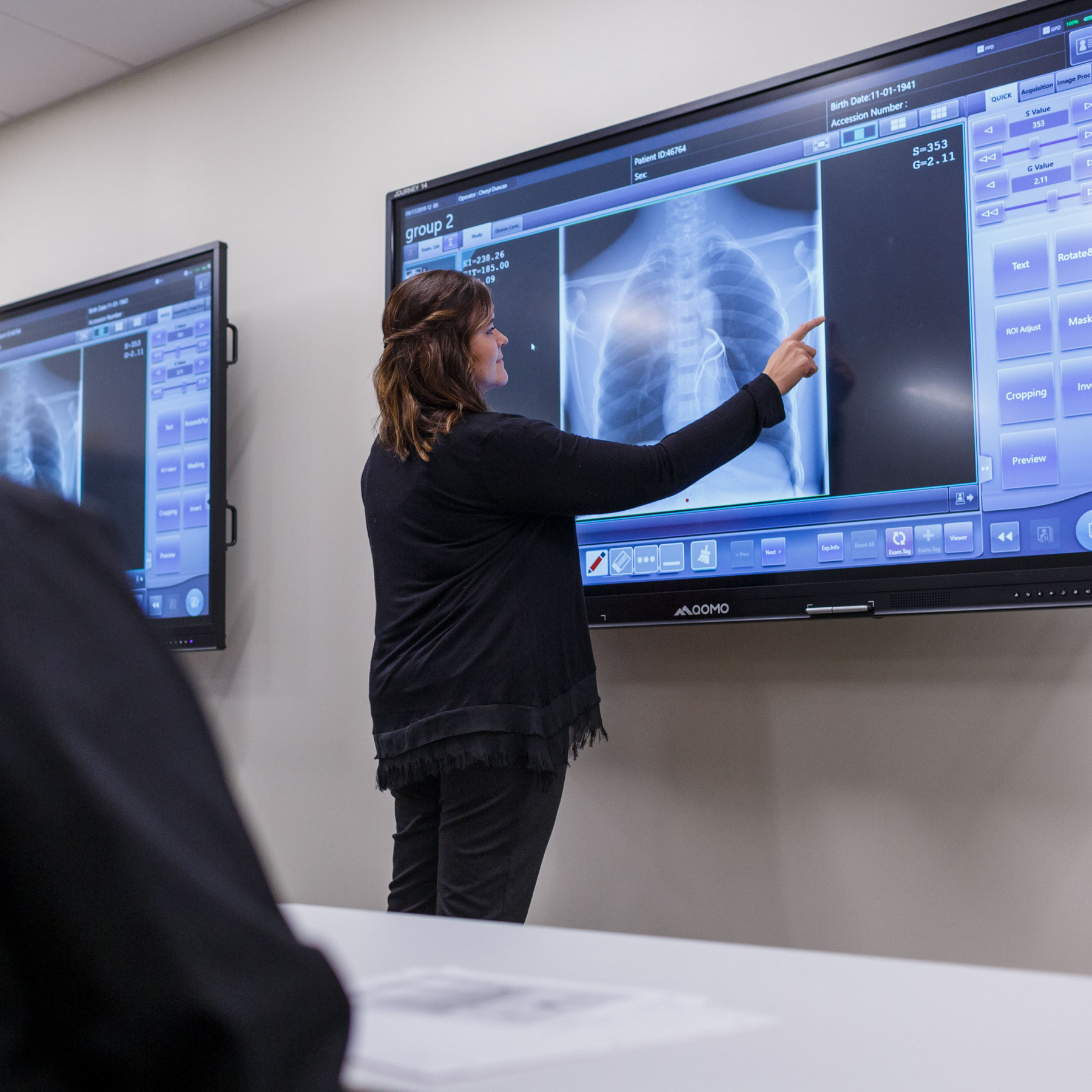 Instructor pointing to x-ray image on monitor.